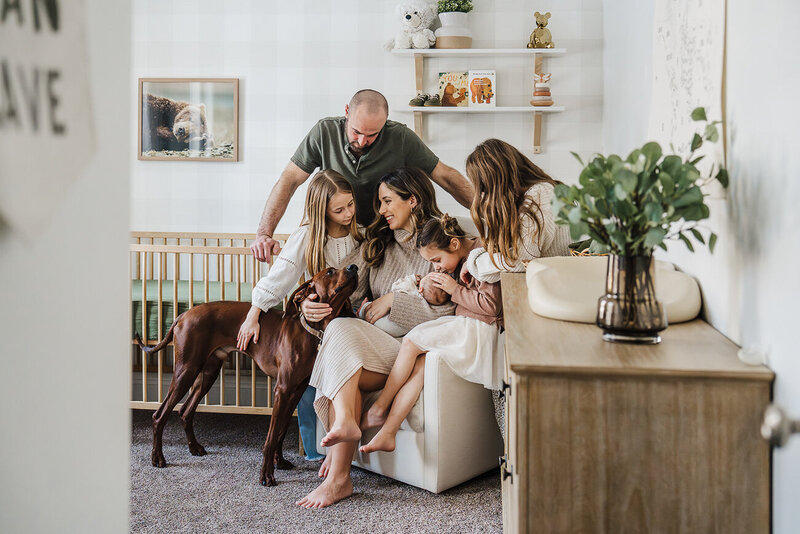 family snuggles together with dog in new baby nursery during boston newborn photos