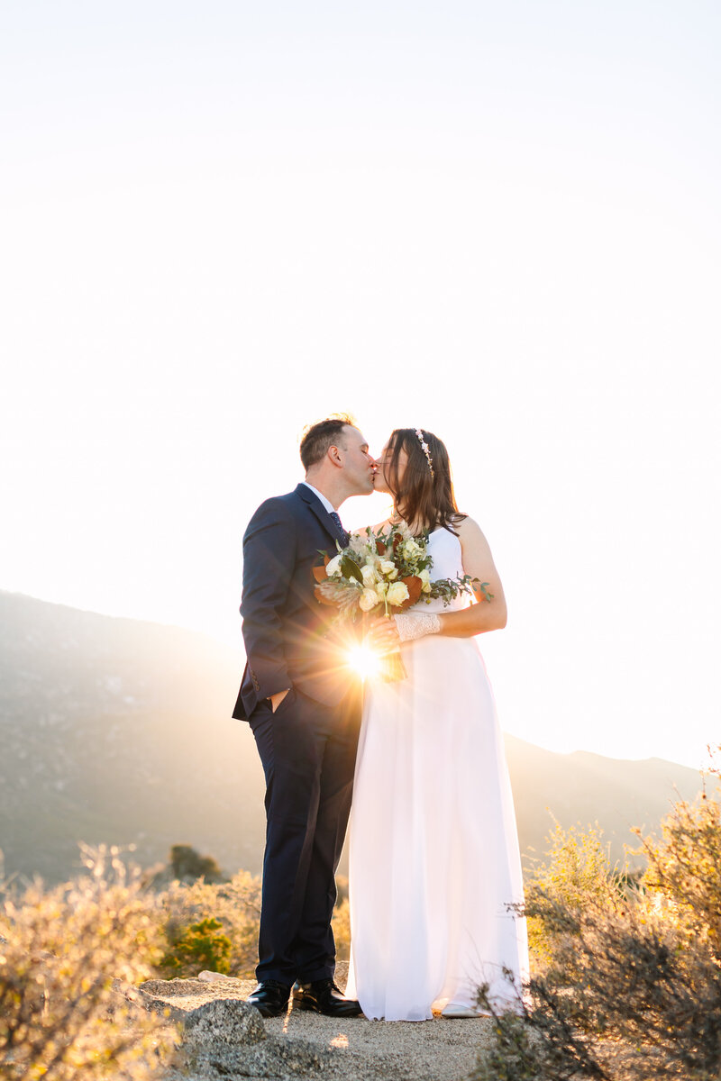 Intimate wedding couples portrait during sunset with sun flare in Palm Springs, CA