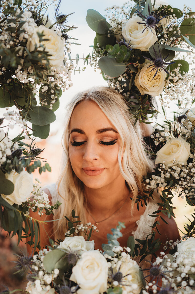 western bride poses with all of her bridesmaids bouquets around her for creative shot  