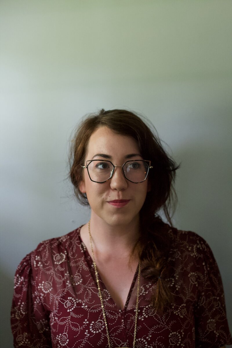 Expressive Figurative painter Kristin McGraw, artist of Kristin McGraw Studio portrait with sage green walls and diffuse light