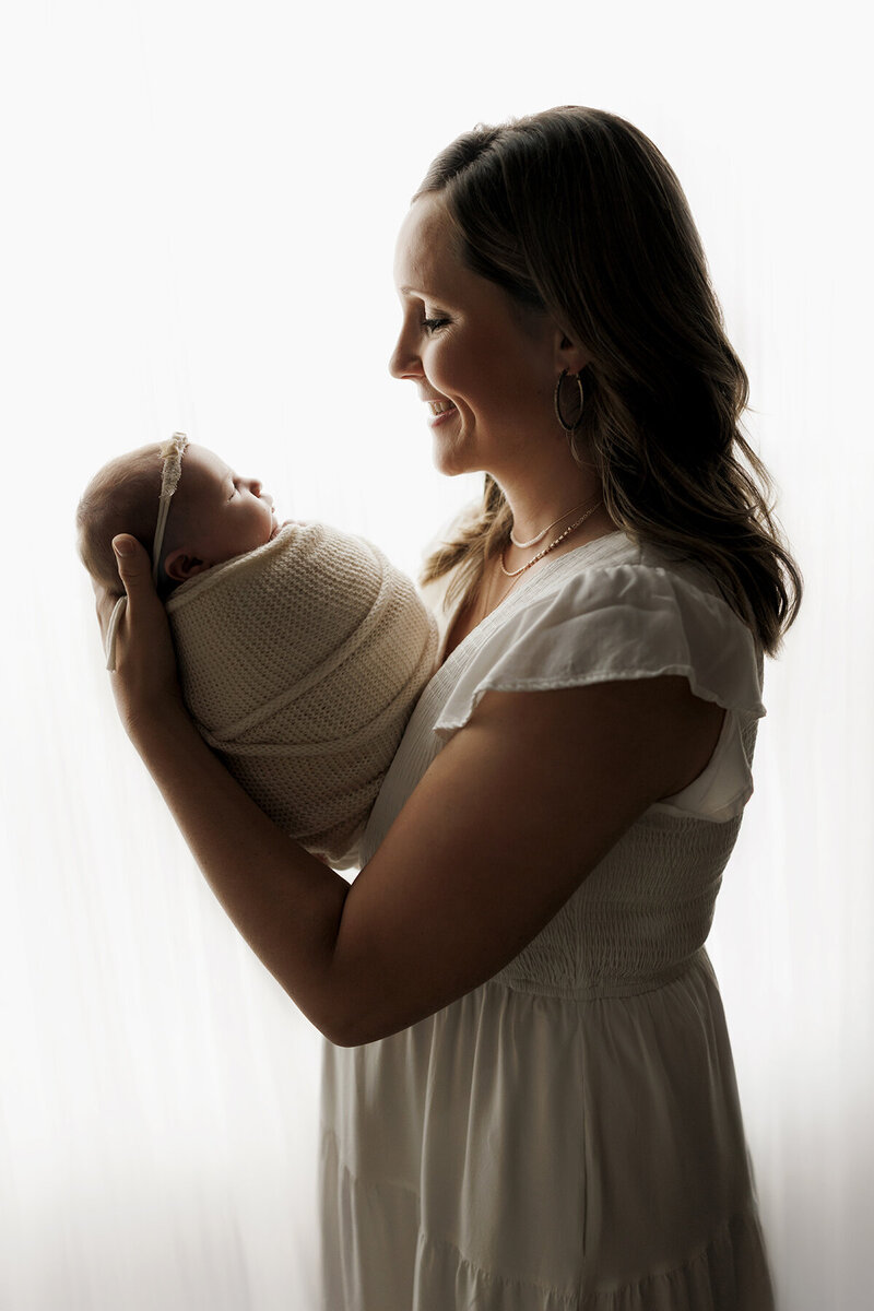 Backlit image of a new mom and her newborn baby girl