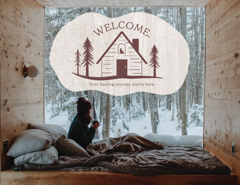 This image shows the Sheri Zanganeh Therapy tagline logo overlayed against an image of a young feminine presenting person sitting in a cabin, holding a mug and wrapped in a thick blanket. A winter scene is visible outside the window.