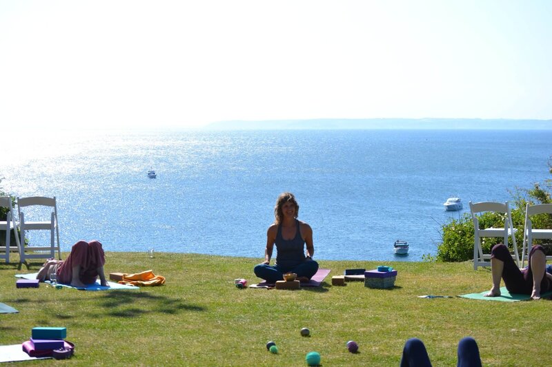 A woman teaching a class on the lawn at Polhawn Fort