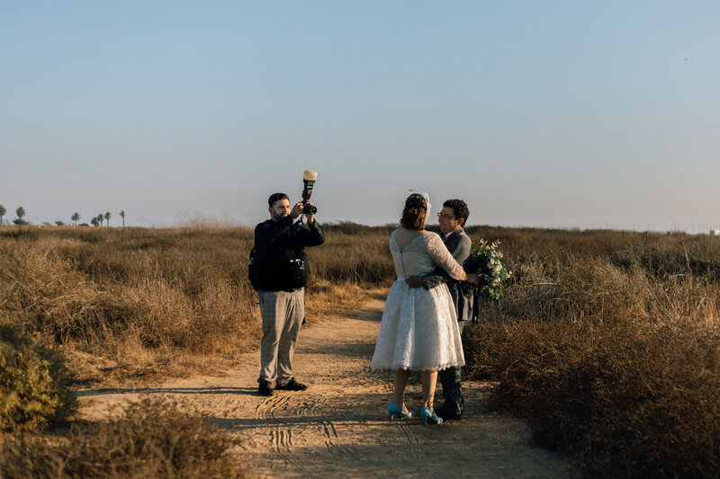 A photographer taking a picture of a wedding couple.