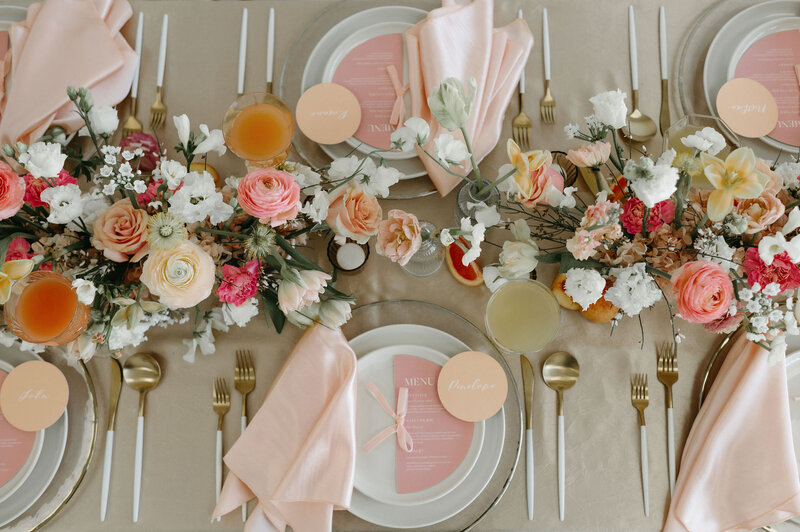 Peach and white florals with white and gold table setting for wedding reception.