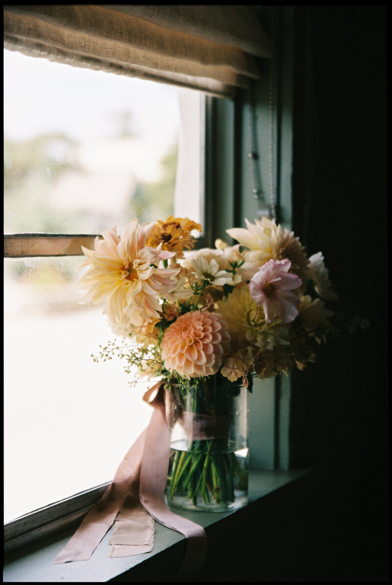 Close-up shot of wedding rings and the bride's shoes, captured in a nostalgic, artistic documentary photography style using both digital and analog film.