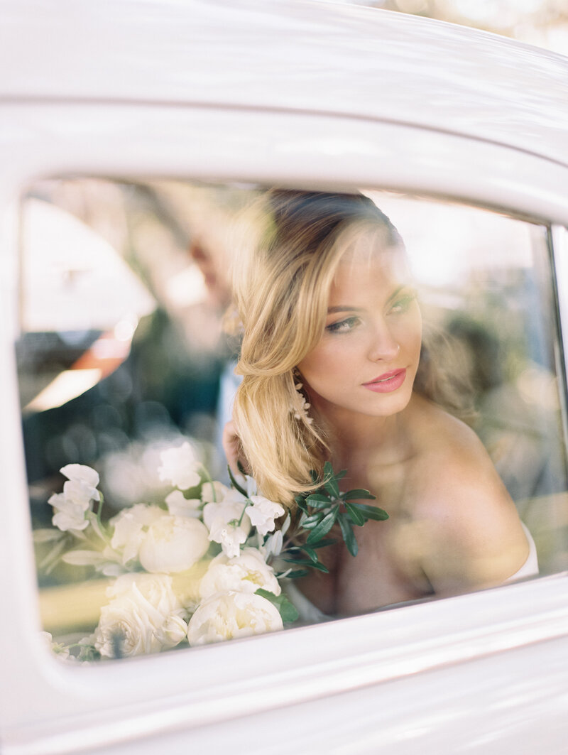 Bride looking out car window photographed by chicago editorial wedding photographer Arielle Peters