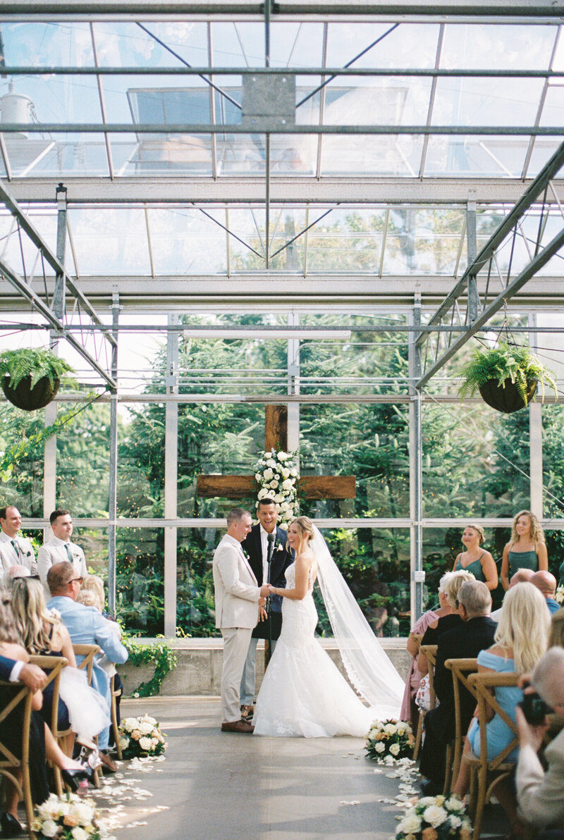 bride and groom in greenhouse during ceremony