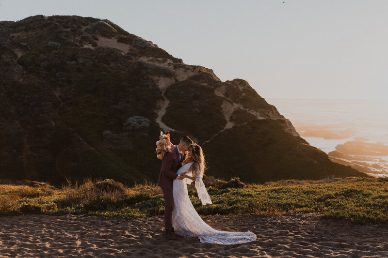 Wedding couple stands in front of a canyon in Zion National Park during a sunrise elopement in Utah