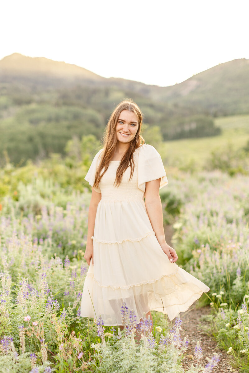 a girl standing in a field in a white dress