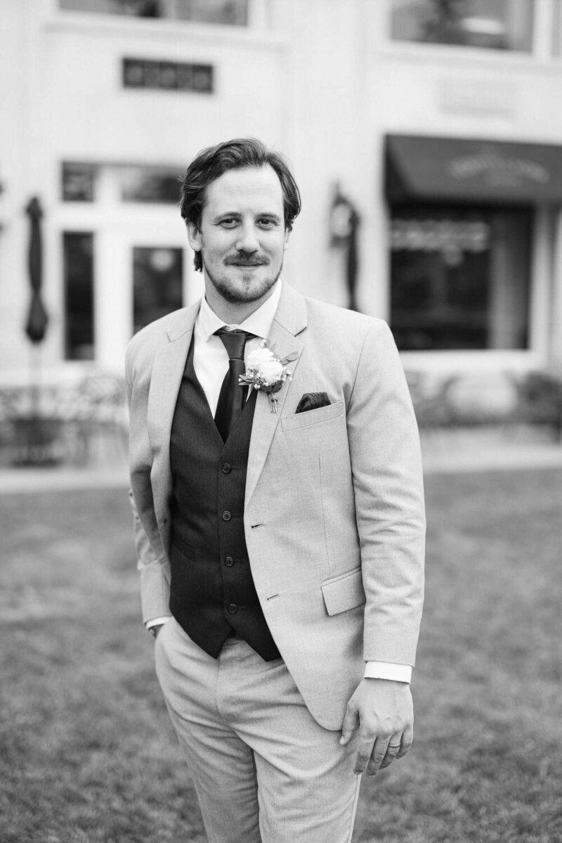 Capture the elegance and charm of a groom's portrait in the lush green garden of Banff Springs Hotel on his wedding day. A perfect blend of natural beauty and timeless style.