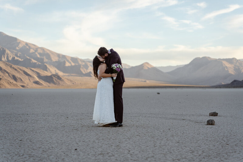 A person in the distance standing on a hill in the desert