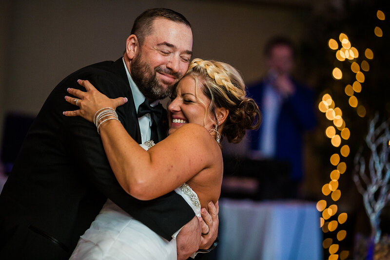 Smiling couple as groom dips bride during first dance