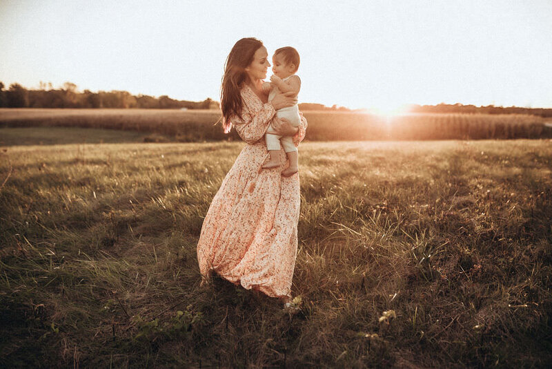 mother holding daughter in field