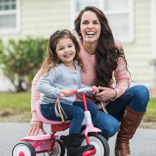 Thrive by Spectrum Pediatrics image for even more services including blog, praise, featured in, and guest speaking is a child riding a bike with mother smiling nearby