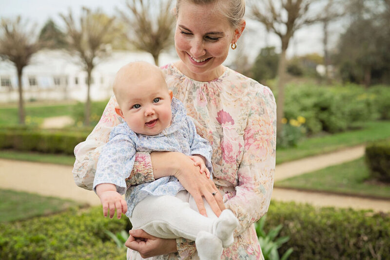 A baby girl held in her mother's arms at Chiswick House Gardens in west London