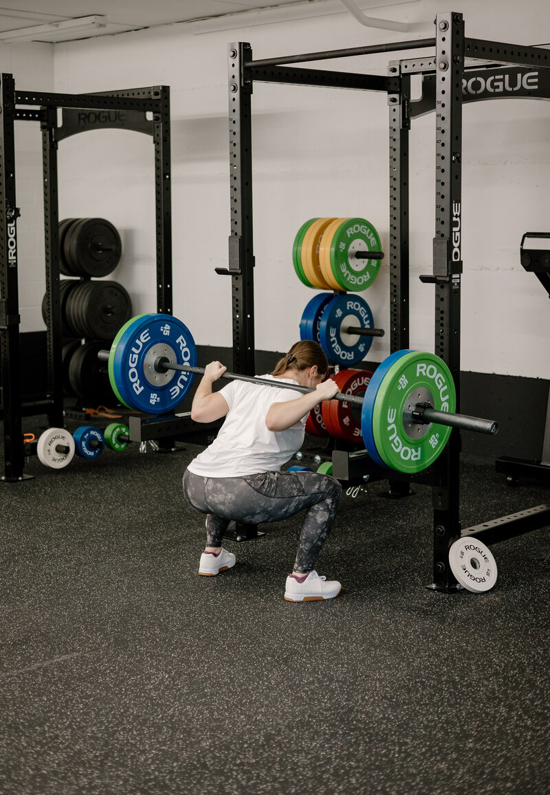 woman holding barbell while standing