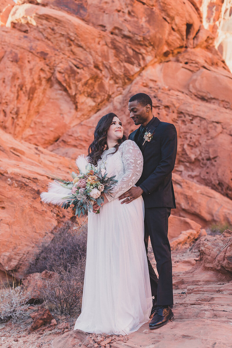 bride and groom embrace during elopement in las vegas desert