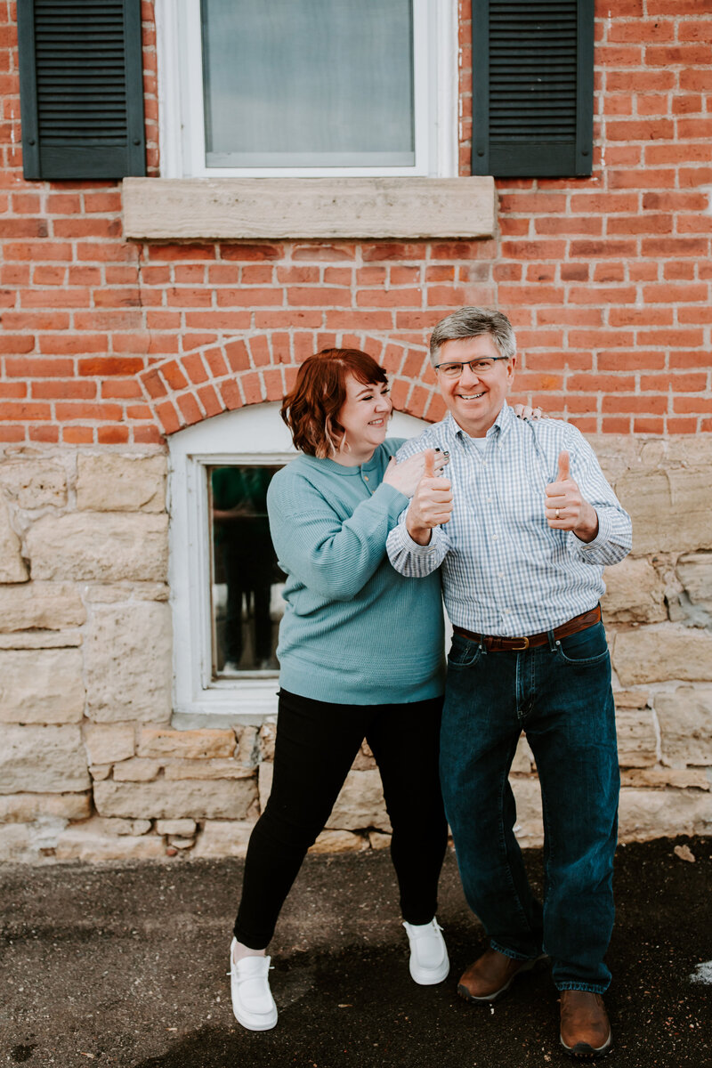 The Abundance Group founders, Ashley Ebert and Dale Henry, smile together behind their desk