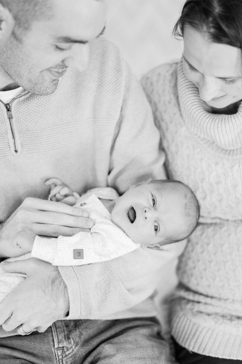 Newborn smiles in parents' arms taken in Sutton, MA 