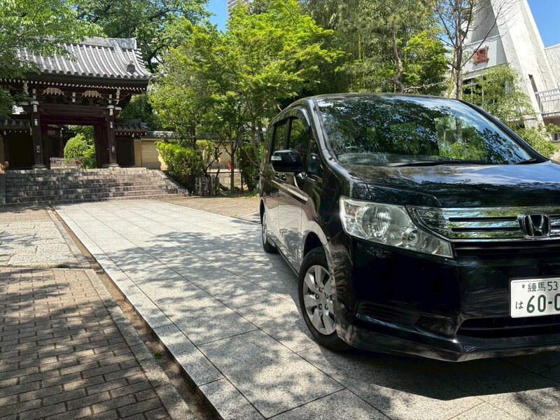 Side view of the Honda Stepwagon parked in front of a serene Japanese temple, blending modern luxury with cultural heritage.