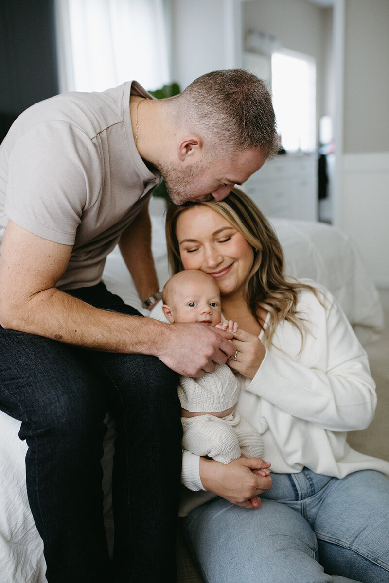 newborn photos of parents snuggling baby