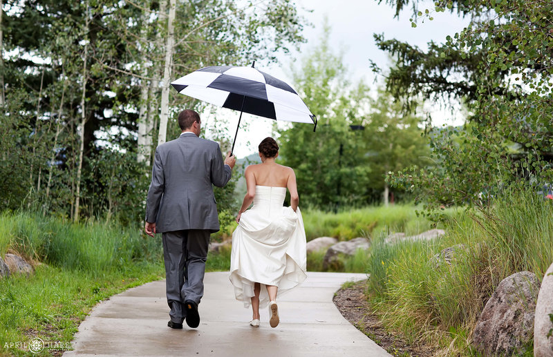 Bride and groom walk along the sidewalk outside of Donovan Pavilion in Vail