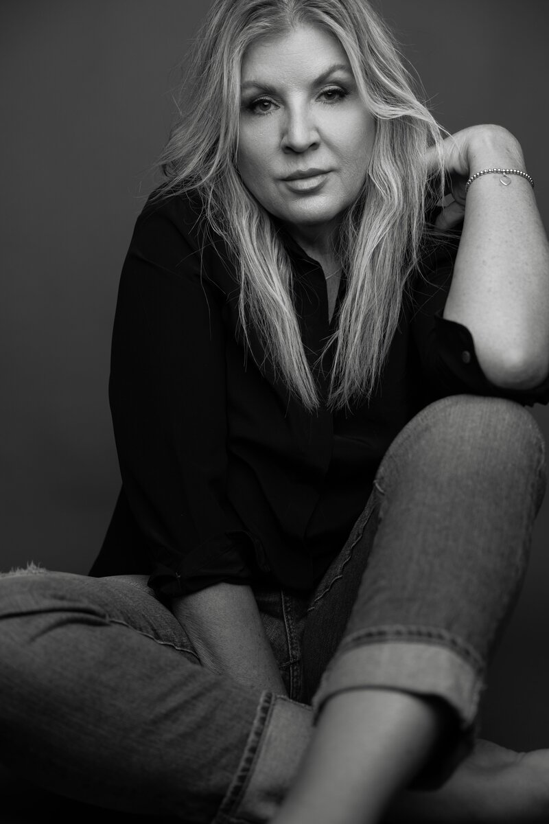Amy Hailstone black and white photo sitting on floor. 