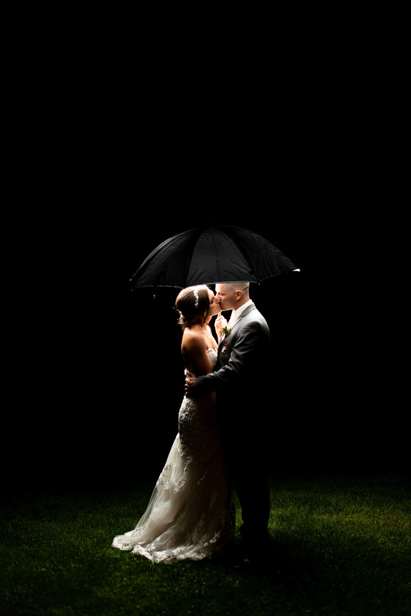 Picture of bride and groom under a black umbrella