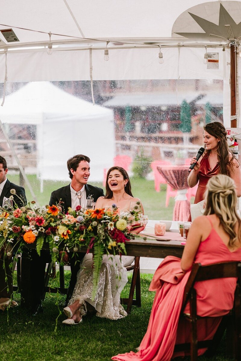 bride and groom laughing during reception toasts