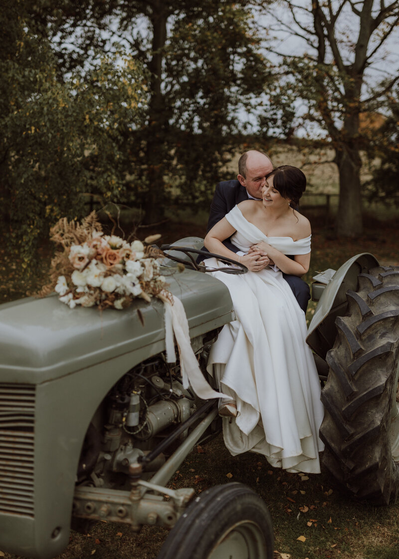 bride and groom on tractor at lyde court herefordshire wedding