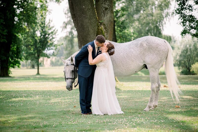 Svatební fotografie novomanželů s koněm ve fine art stylu