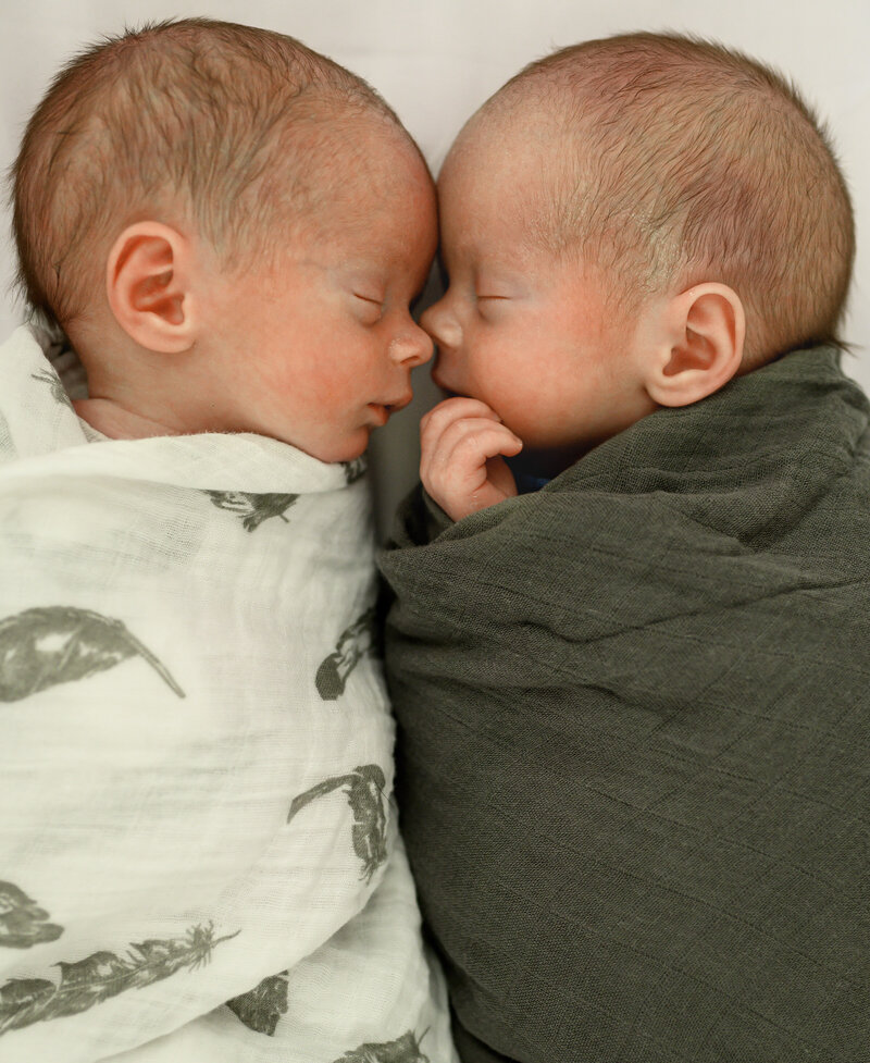 Mother holding sleepy baby in arms