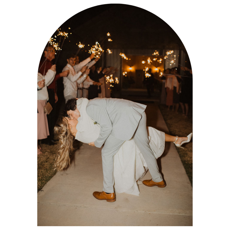 Bride and groom kissing during their sparkler exit