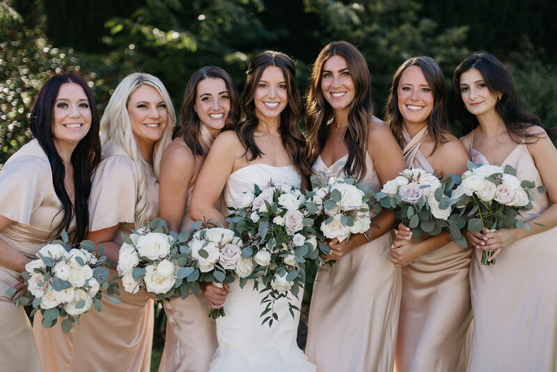 bridesmaids with bride holding flowers
