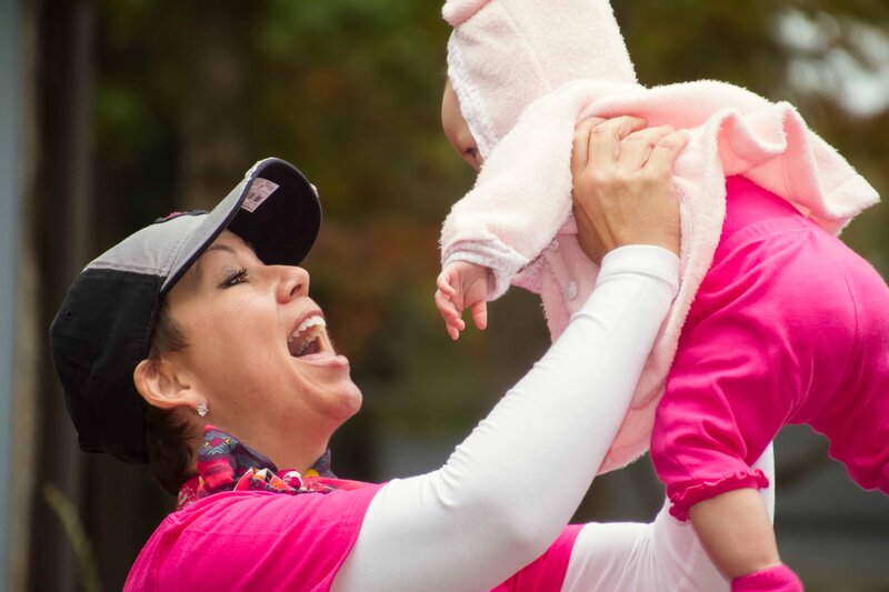 Race for Cure participant holding young child with Ron Schroll Photography in Hickory, Nc