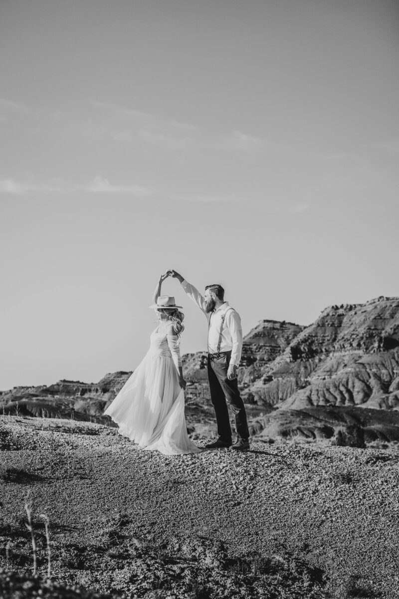 groom twirling bride in high desert mountain wedding