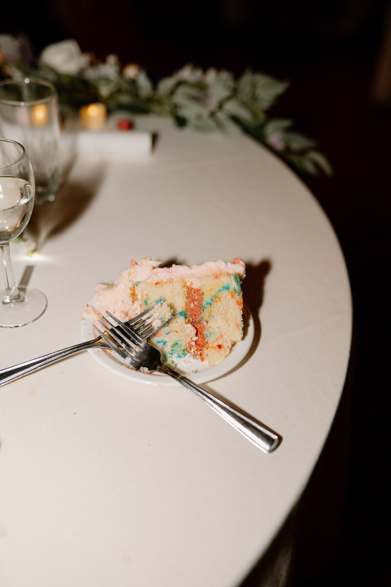 Partially eaten slice of colorful wedding cake