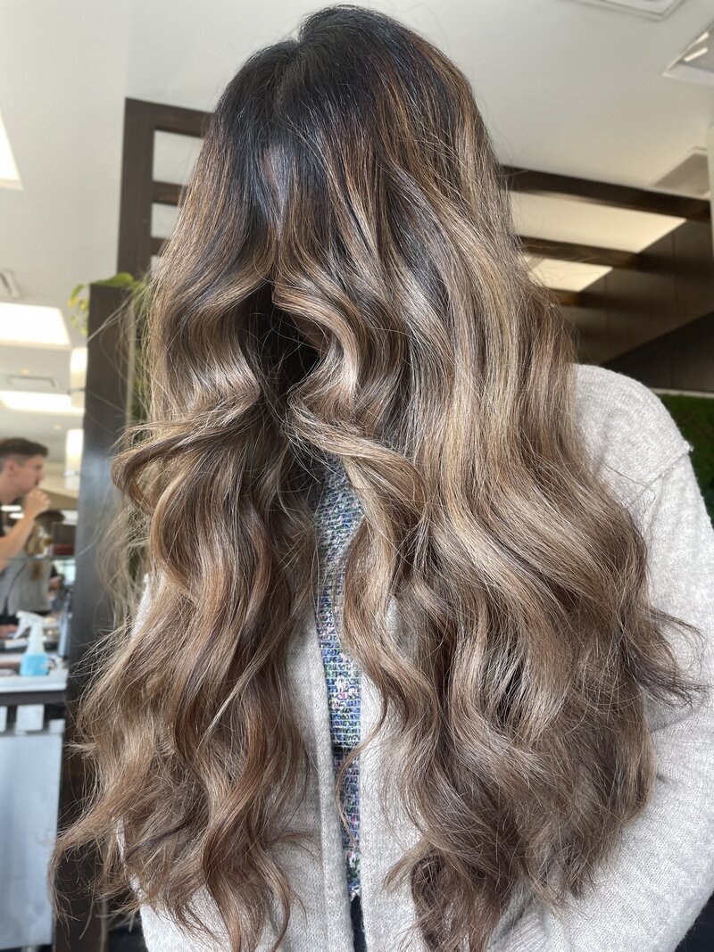 Woman with long brown hair and highlights