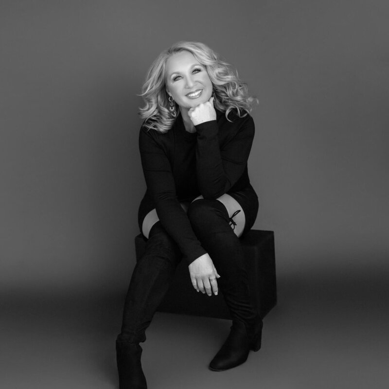 Stylish black and white portrait of a woman in thigh-high boots.