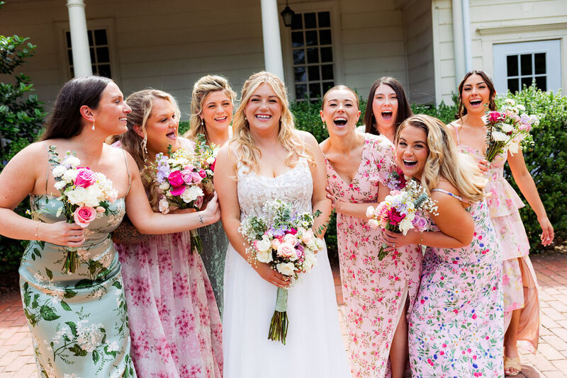 A newlywed laughing with their wedding party