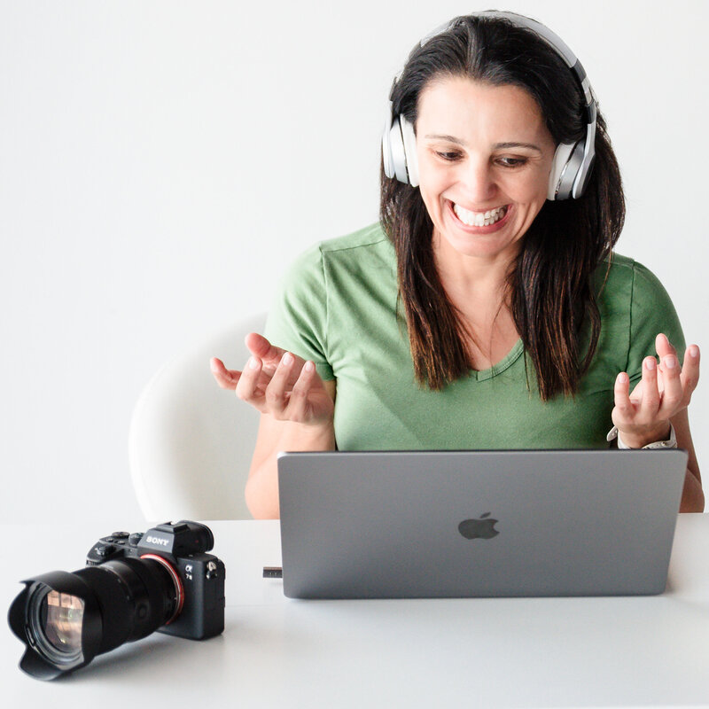 brand photographer in a call with a client, laptop and camera on the desk