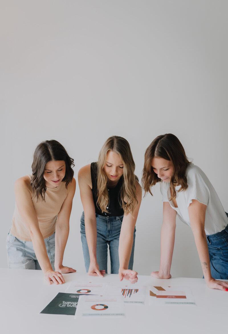 Megan Evans and her team members looking at financial papers laid out on a table