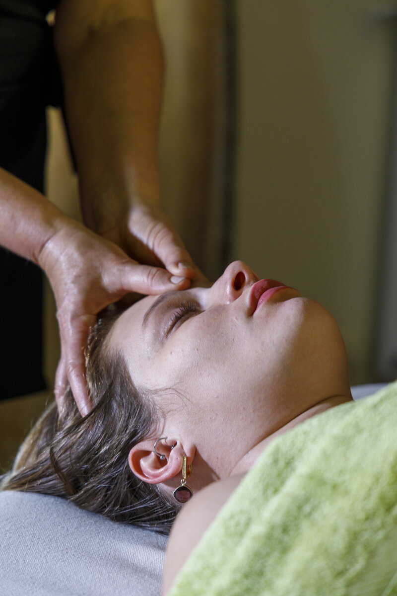 Mains massant la tête d'une femme