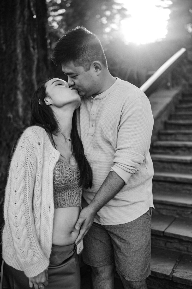 couple being photographed in a field of flowers by Portland maternity photographer