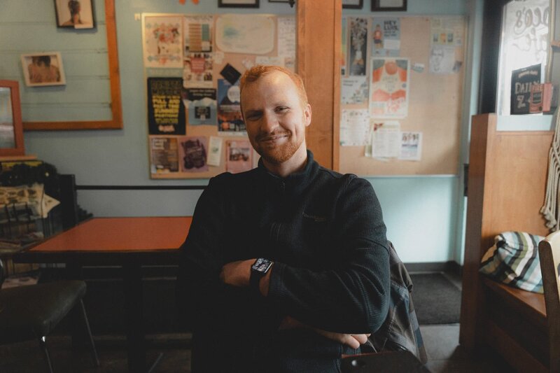 Wedding Photographer Connor Esau smiling and sitting in a coffee shop