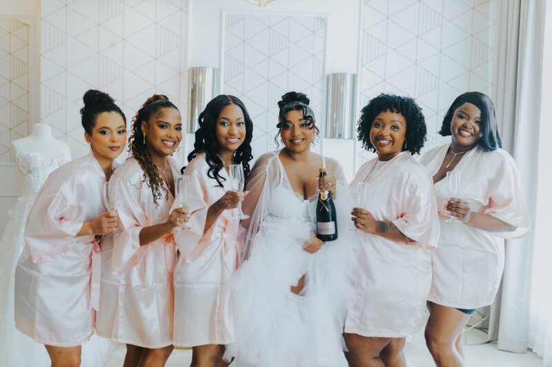 Bridesmaids pose with champagne.