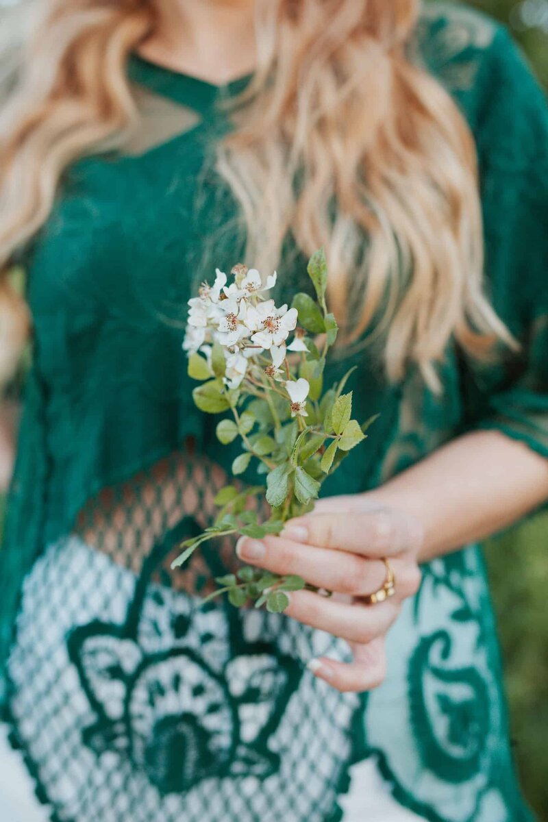 Close up of Kristin holding a flower blossom