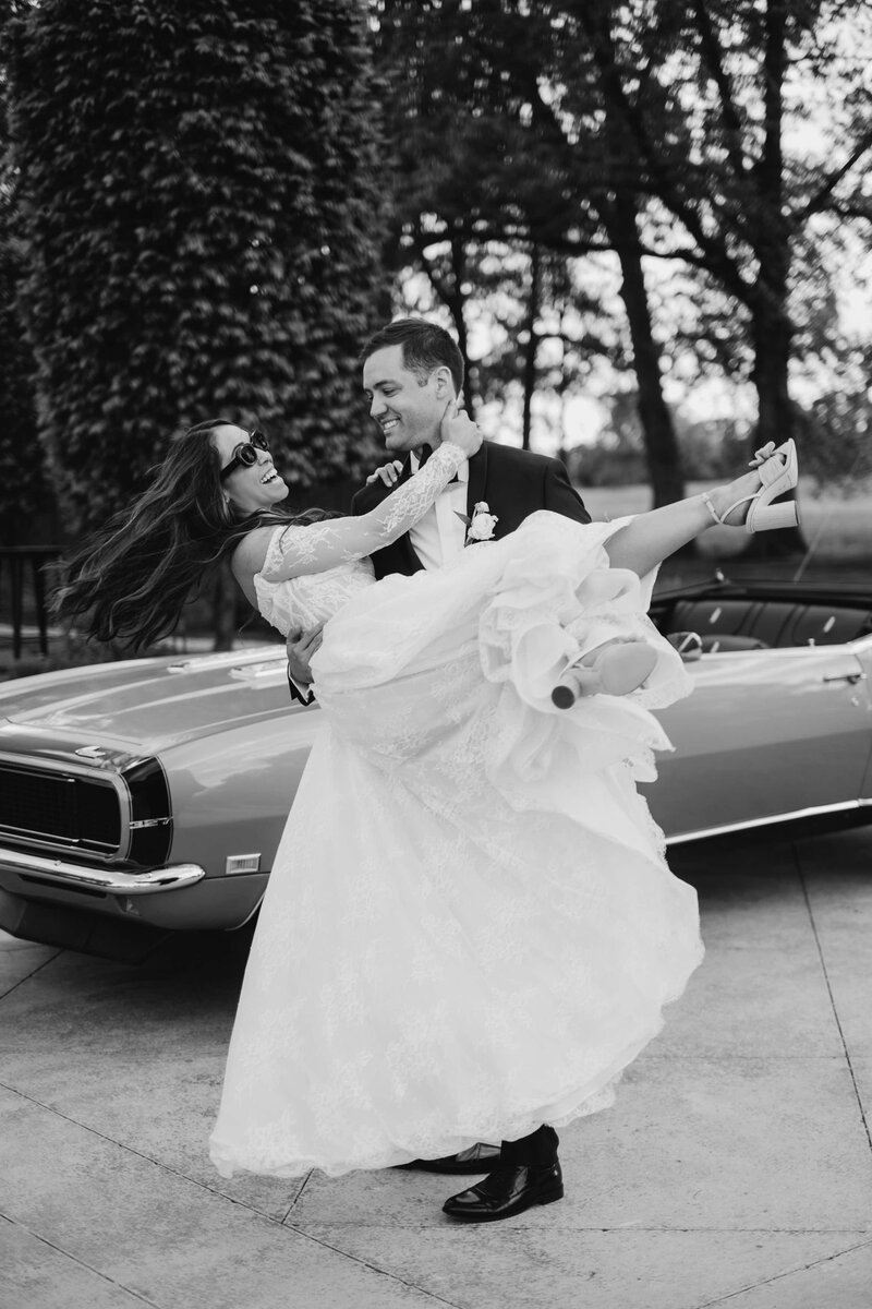 groom carrying bride to the car after wilmington north carolina wedding