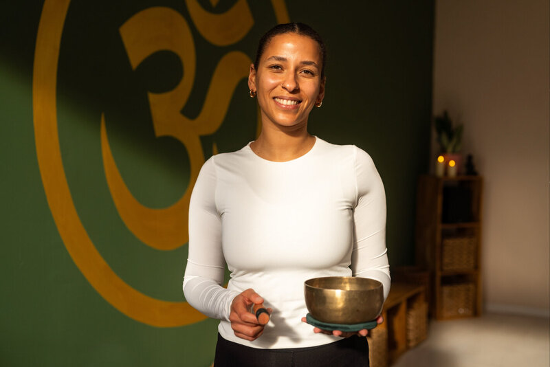Yogastudio-Atmosphäre mit Nina und einer Klangschale in den Händen